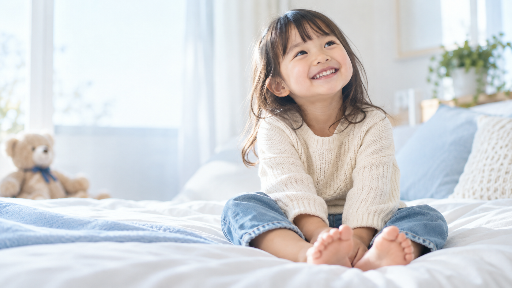 明るい部屋で座り、笑顔を見せる幼児